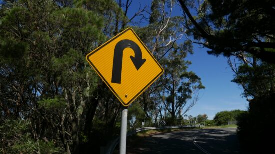 A yellow road sign indicating a sharp bend or corner in the road